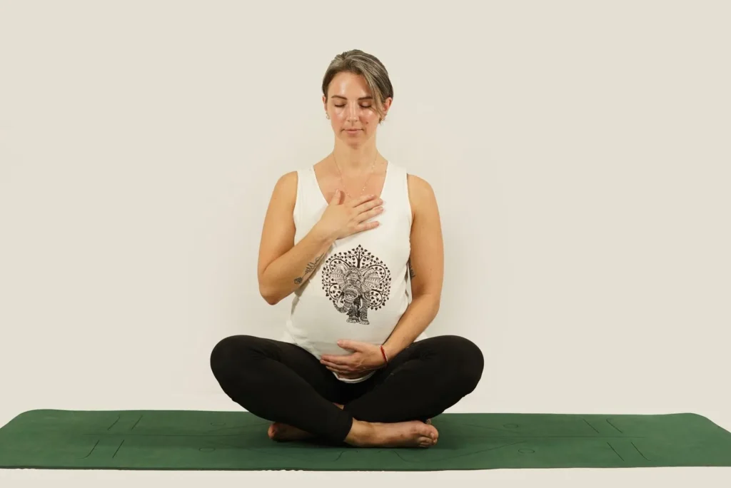 Mujer embarazada meditando en una esterilla