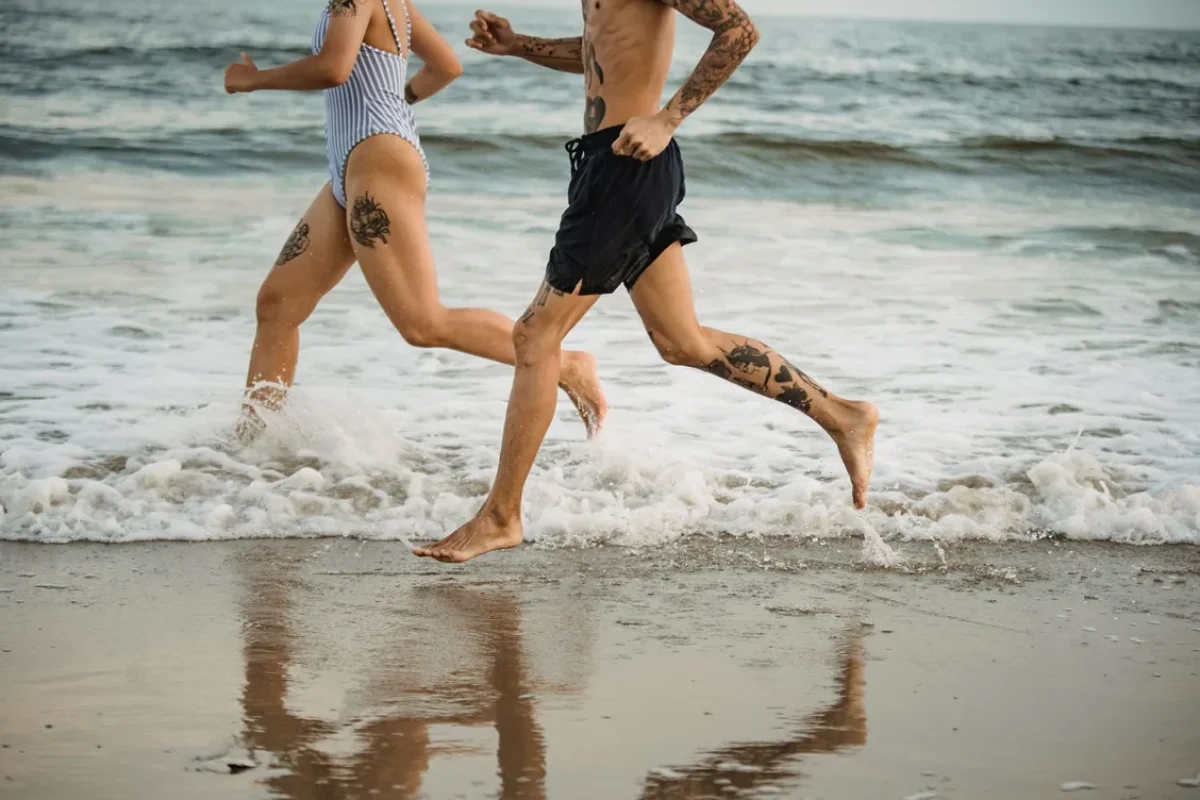 Pareja corriendo por la orilla de la playa
